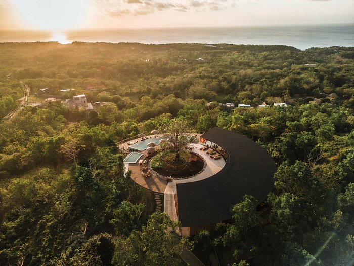 Aerial of a wellness venue nested in the jungle at sunset